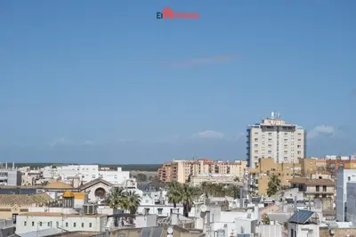 a city skyline with buildings and palm trees at El Anfitrión - Carmen Viejo in Sanlúcar de Barrameda