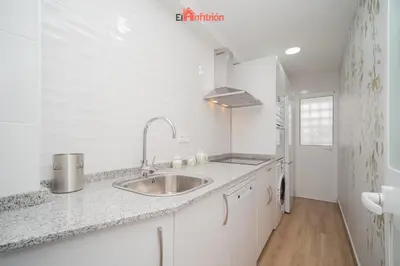 a white kitchen with a sink and a counter at El Anfitrión - Carmen Viejo in Sanlúcar de Barrameda