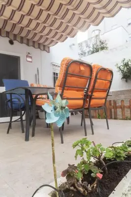 a patio with chairs and a table with a flower at Murillo by Gades Gestión in Cádiz