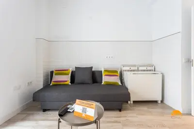 a bedroom with a bed and a small refrigerator at Bajo el Falla by Cadiz Time in Cádiz