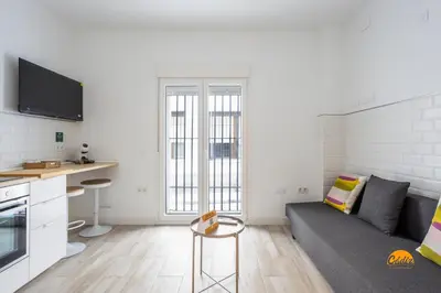 a white living room with a couch and a table at Bajo el Falla by Cadiz Time in Cádiz