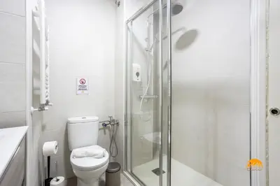 a bathroom with a toilet and a glass shower at Bajo el Falla by Cadiz Time in Cádiz