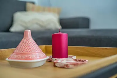 a pink candle sitting on a wooden table at Apartamento céntrico con vistas in Arcos de la Frontera