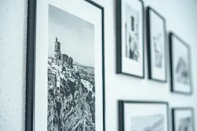 a row of framed photographs on a wall in a room at Apartamento céntrico con vistas in Arcos de la Frontera