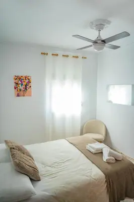 a bedroom with a bed with a ceiling fan at Apartamento céntrico con vistas in Arcos de la Frontera