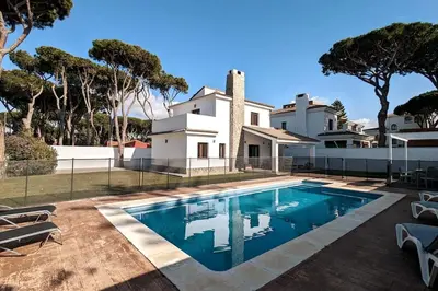 a swimming pool in front of a house at La casita de la playa in Chiclana de la Frontera