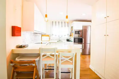 a kitchen with a table and chairs and a refrigerator at La casita de la playa in Chiclana de la Frontera