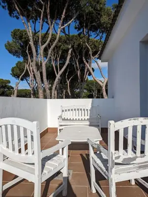 two white chairs and a table on a patio at La casita de la playa in Chiclana de la Frontera