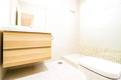 a bathroom with a sink and a toilet and a mirror at La casita de la playa in Chiclana de la Frontera