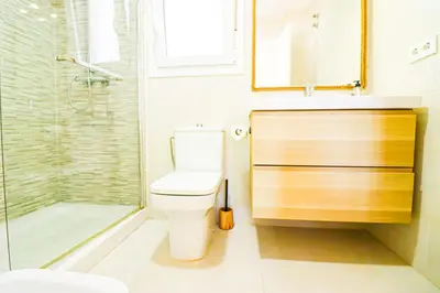 a bathroom with a toilet and a glass shower at La casita de la playa in Chiclana de la Frontera