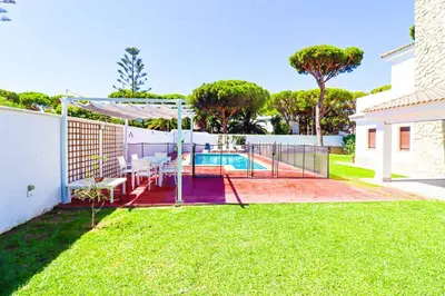 a backyard with a pool and a tennis court at La casita de la playa in Chiclana de la Frontera