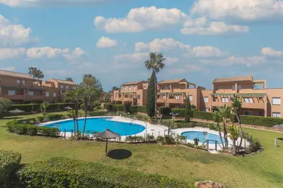 an aerial view of an apartment complex with a swimming pool at Urbanización Jardín del Golf 1 in Novo Sancti Petri