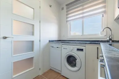 a white laundry room with a washer and dryer at Urbanización Jardín del Golf 1 in Novo Sancti Petri