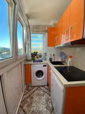 a small kitchen with orange cabinets and a washing machine at GATU Villa Dante Playa Victoria Parking gratuito, 