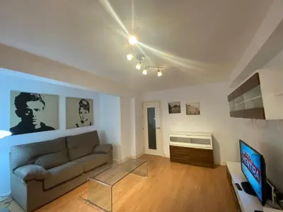a living room with a couch and a tv at GATU Villa Dante Playa Victoria Parking gratuito, 