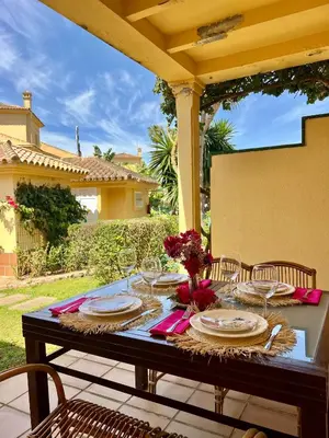a table with plates and wine glasses on a patio at Novo Sancti Petri (Green 11) in Novo Sancti Petri