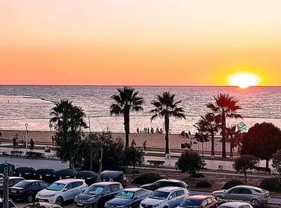 a group of cars parked in a parking lot near the beach at Piso primera línea de playa in Chipiona