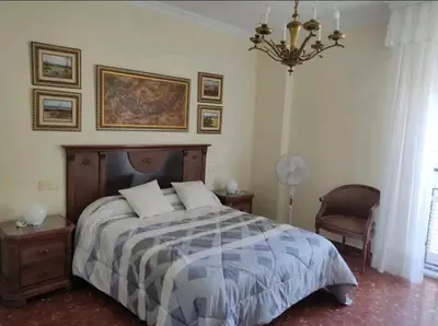 a bedroom with a bed and a chandelier at Piso primera línea de playa in Chipiona