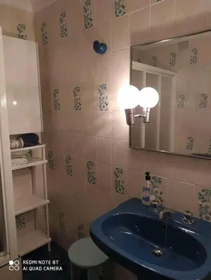 a bathroom with a blue sink and a mirror at Piso primera línea de playa in Chipiona