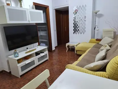a living room with a couch and a flat screen tv at El Deseo in Novo Sancti Petri