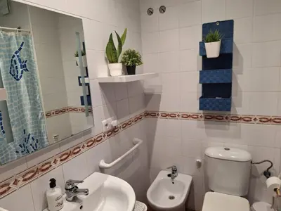 a white bathroom with a toilet and a sink at El Deseo in Novo Sancti Petri