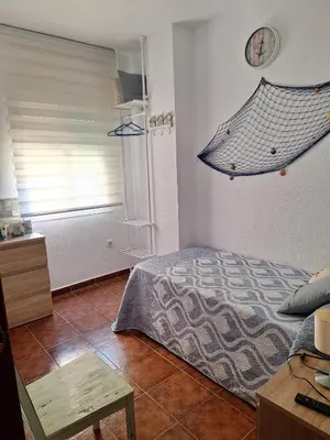 a bedroom with a bed and a clock on the wall at El Deseo in Novo Sancti Petri