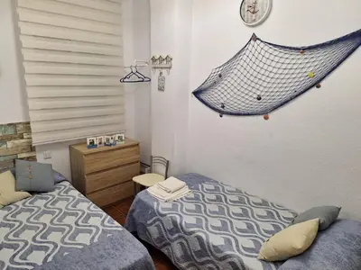 a bedroom with two beds and a net on the wall at El Deseo in Novo Sancti Petri