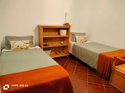 a bedroom with two beds and a book shelf at Habitación acogedora y sencilla in El Puerto de Santa María