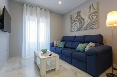 a blue couch in a living room with a table at Apartamento Cádiz Mirador by Isa in Cádiz