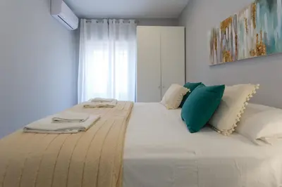 a bedroom with a large white bed with green pillows at Apartamento Cádiz Mirador by Isa in Cádiz