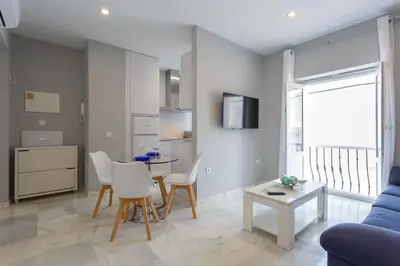 a living room with a blue couch and a table at Apartamento Cádiz Mirador by Isa in Cádiz