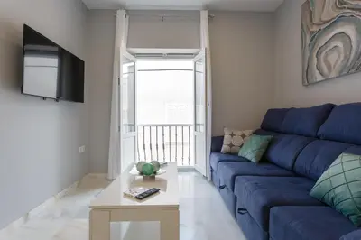 a living room with a blue couch and a table at Apartamento Cádiz Mirador by Isa in Cádiz
