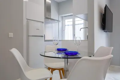 a dining room with a glass table and white chairs at Apartamento Cádiz Mirador by Isa in Cádiz