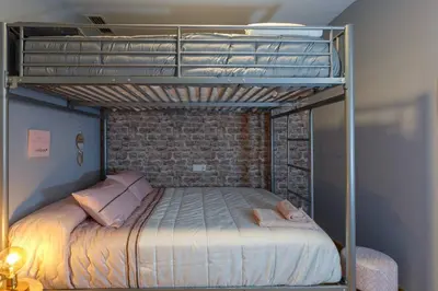 a bunk bed in a room with a brick wall at Apartamento El Mercado - Ole Solutions in Jerez de la Frontera