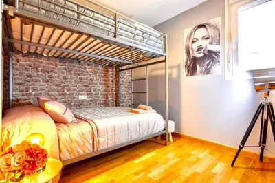 a bedroom with a bunk bed and a brick wall at Apartamento El Mercado - Ole Solutions in Jerez de la Frontera