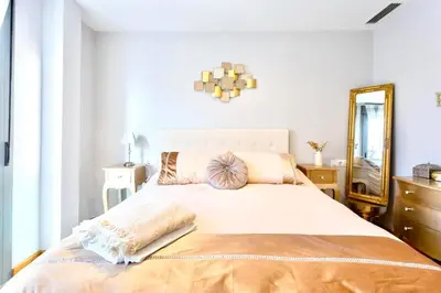 a bedroom with a large bed with a mirror at Apartamento El Mercado - Ole Solutions in Jerez de la Frontera