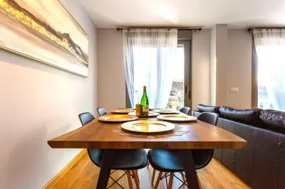 a dining room table with chairs and a bottle of wine at Apartamento El Mercado - Ole Solutions in Jerez de la Frontera