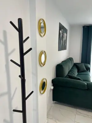 a living room with a green couch and two mirrors at Mrati - Playa in Puerto Real
