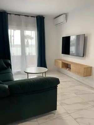 a living room with a green couch and a tv at Mrati - Playa in Puerto Real