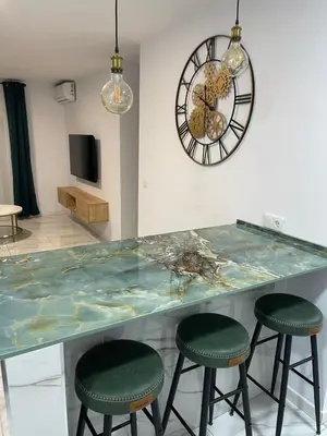 a counter with two stools and a clock on the wall at Mrati - Playa in Puerto Real