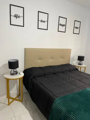 a bedroom with a bed and three pictures on the wall at Mrati - Playa in Puerto Real