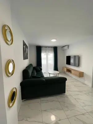 a living room with a black couch and a tv at Mrati - Playa in Puerto Real
