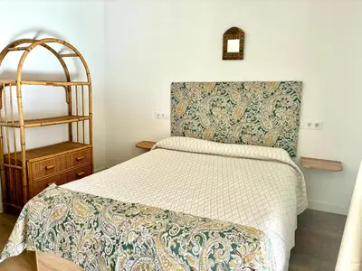 a small bedroom with a bed and a shelf at Apartamento Gallo Azul in Jerez de la Frontera