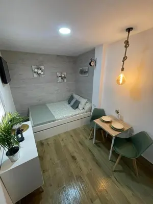 a small room with a bed and a table at Estudio BF jacuzzi jerez in Jerez de la Frontera
