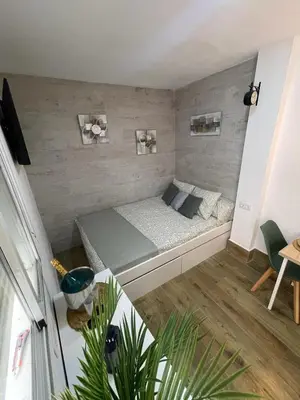 a small bedroom with a bed in a room at Estudio BF jacuzzi jerez in Jerez de la Frontera