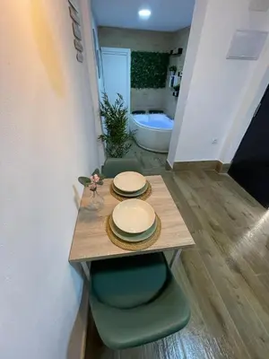 a table with plates on it in a room at Estudio BF jacuzzi jerez in Jerez de la Frontera
