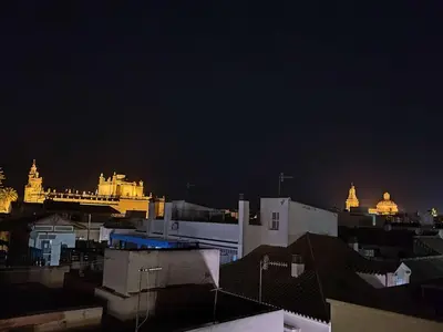 a view of a city at night with buildings at L' Alcoba Rooftop in Sanlúcar de Barrameda