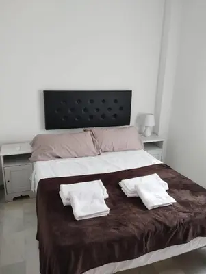 a bedroom with a bed with two towels on it at L' Alcoba Rooftop in Sanlúcar de Barrameda
