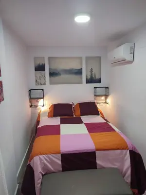 a bedroom with a bed with a colorful blanket at Apartamento Gitanilla in Chipiona