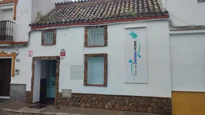 a white building with a sign on it at Apartamento Gitanilla in Chipiona